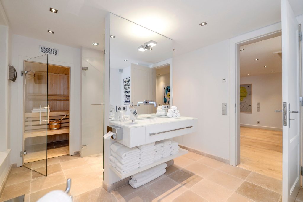 Modernes Badezimmer mit Wellnessbereich und eigener Sauna in einem Ferienhaus auf Sylt