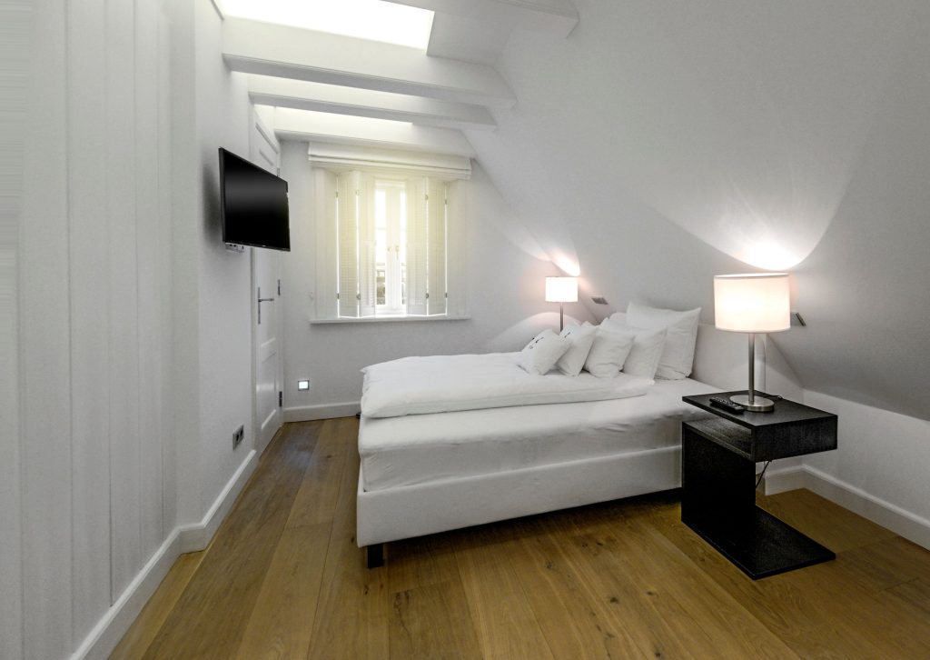 Schlafzimmer in weiß eines Ferienhauses auf Sylt