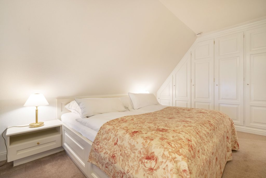Doppelbett in einem Schlafzimmer einer Ferienunterkunft auf Sylt