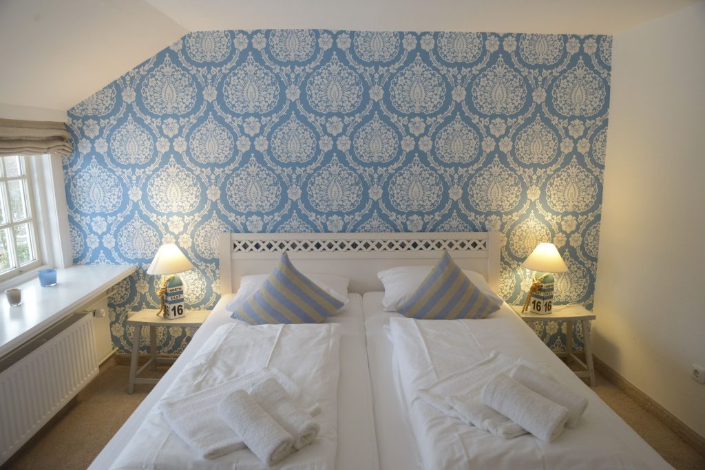 Ein Doppelbett in einem Schlafzimmer einer Ferienwohnung auf Sylt.