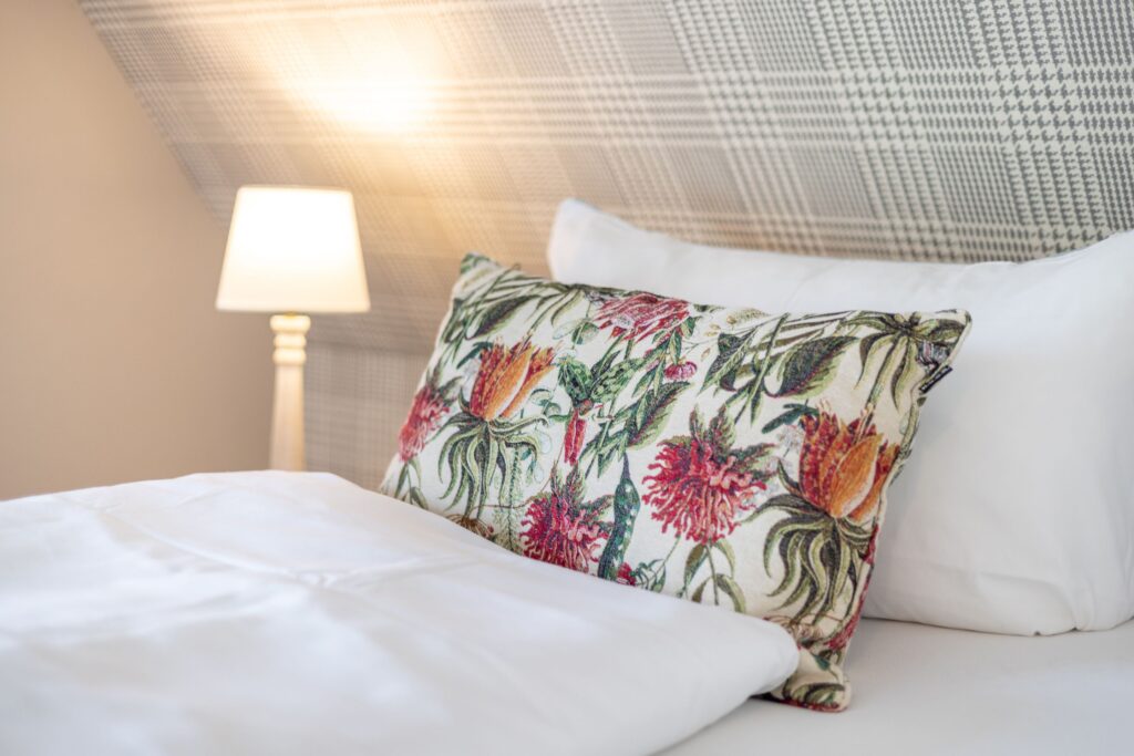 Bett mit Blumenkissen in Ferienwohnung in Keitum