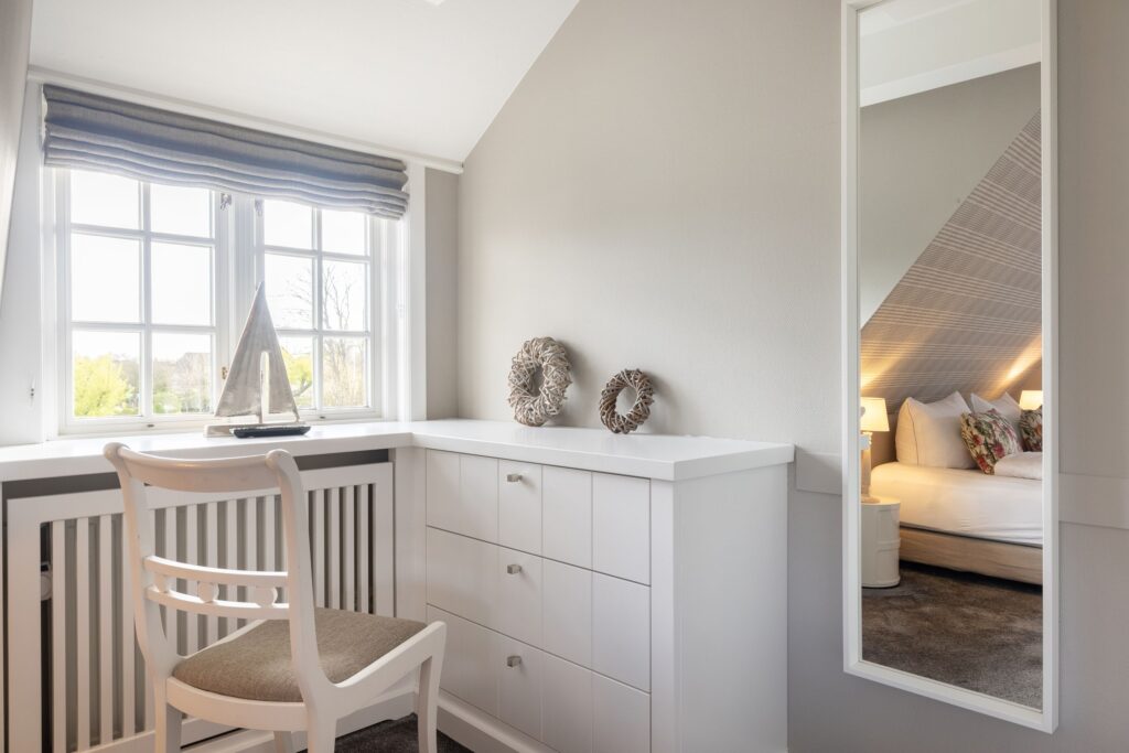 Schlafzimmer mit Spiegel und Fenster